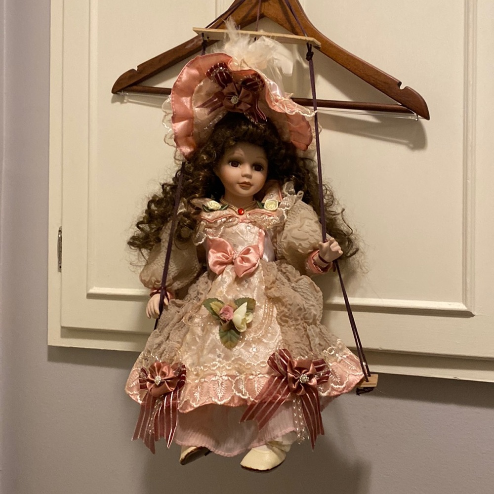 Goldenvale porcelain doll on swing